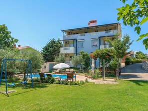 A multi-story building with a swimming pool, outdoor seating, and a playground. - Lovely apartment for 5 people with pool, WIFI, A/C, TV and terrace (Labin)