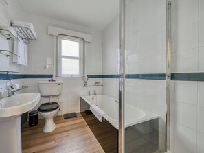 A bathroom with a toilet, sink, bathtub, and a glass shower enclosure.