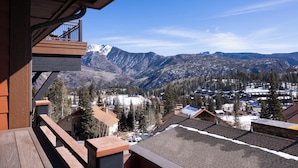 A wooden balcony overlooking a snowy mountain landscape with houses and trees. - Purgatory Lodge 405 - Managed by Purgatory Resort (Durango)