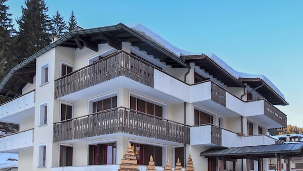 A multi-story hotel with balconies, a covered entrance, and a snow-covered landscape. - Lovely apartment for 2 guests with WIFI and TV (Ragoli)
