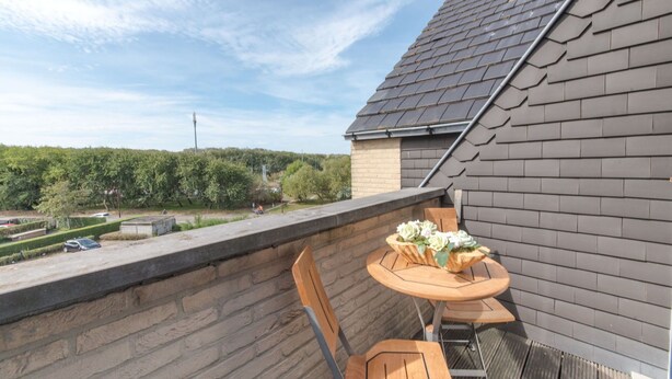A rooftop terrace with a table and chairs, a view of the surrounding area, and a sloped roof. - Lovely apartment for 4 guests with WIFI, TV and balcony (Bruges)