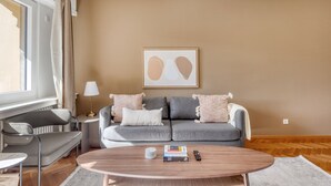 Una sala de estar moderna con un sofá gris, una mesa de centro y una lámpara.