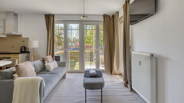 Un salon moderne avec un canapé, une table basse et une vue sur un balcon.