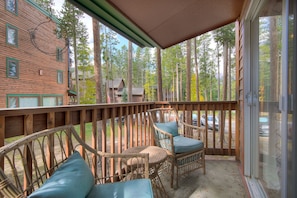 Relax on the deck surrounded by a forested area with a clear view of the surrounding landscape.
