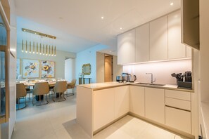 A modern kitchen with a central island, a dining area with a table and chairs, and a kitchen counter with appliances.