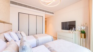 Un dormitorio moderno con una cama grande, televisión y cómoda.