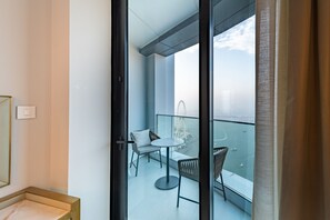 Ein Balkon mit Blick auf ein Riesenrad und ein Gewässer.