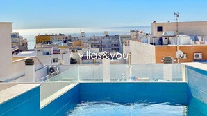 Una piscina sul tetto con vista panoramica sul mare e sulla città.