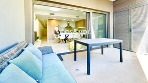Un soggiorno open space con un divano, un tavolo e una cucina sullo sfondo.