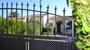 A gated property with a house featuring a tiled roof and a covered patio area. - Las Palmeras 5 - L'Estartit, Torre Gran (Estartit (L´))