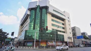 Un edificio de varios pisos con fachada de vidrio moderna, situado en una intersección.