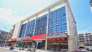 Um edifício moderno com várias lojas no andar térreo, com placas em idioma estrangeiro.