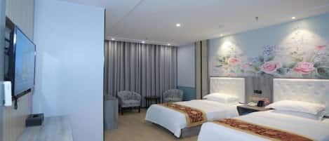 A hotel room with two beds, a TV, a desk, and a wall with floral artwork.