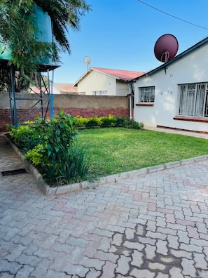 A residential property with a paved driveway, a well-maintained lawn, and a satellite dish.