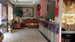 A lobby with a marble floor, a sofa, a coffee table, and a reception desk.