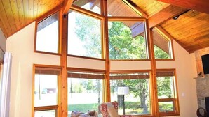 A room with large windows, a fireplace, and a leather sofa. - Paradise in Island Park! -Best location in Island Park 22 Miles from Yellowstone (Island Park)