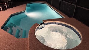 En swimmingpool med kakelbeklädd kant och ett bubbelbad.