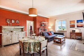 Un salon avec une cheminée, un canapé, une table à manger et une vue par la fenêtre.