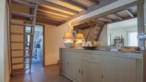 A kitchen with a wooden staircase, a counter with two lamps, and a mirror above it. - Villa Filokalia With Exceptional View, Kastro Kyllini, Greece (Kastro Kyllini)
