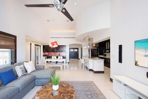 A modern living room with a sofa, coffee table, and a ceiling fan.