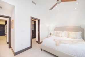 A bedroom with a large bed, a ceiling fan, and a walk-in closet.