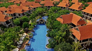 A resort with multiple buildings, a central swimming pool, and palm trees. - Luxury Danang Beach Pool Villa (Da Nang)