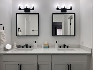 A modern bathroom with two sinks, a large mirror, and a towel rack. - HEATED Pool, Spacious home 7 MIN to airport* (Las Vegas)