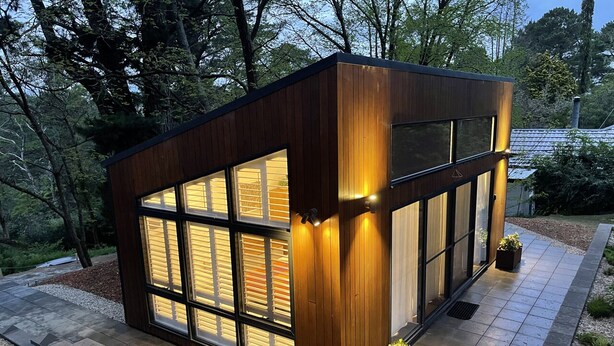 A modern wooden cabin with large windows, surrounded by a garden and trees. - Contemporary, Stylish One Bedroom Studio. (Katoomba)