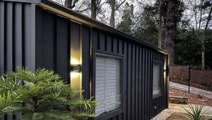 A modern, black exterior building with two windows and a small porch area. - Contemporary, Stylish One Bedroom Studio. (Katoomba)