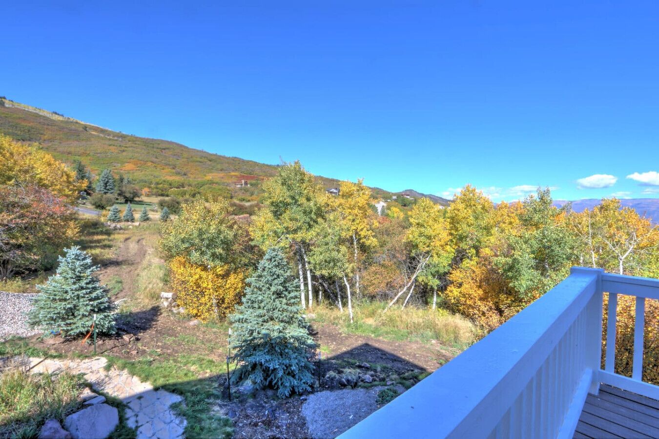 Une terrasse offrant une vue sur un paysage montagneux aux couleurs automnales.