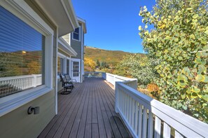 Step out onto the covered porch from this inviting deck, surrounded by lush trees and a serene natural setting.