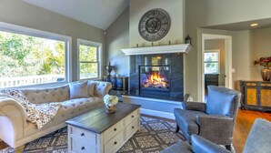 Una sala de estar con chimenea, un sofá, una mesa de centro y un sillón.