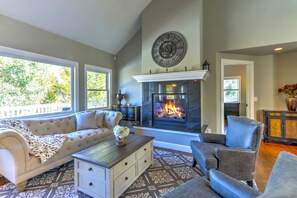 Cozy living room with a fireplace, comfortable seating area, and large windows.