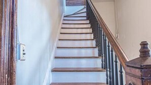 A wooden staircase with white steps leading up to a landing.