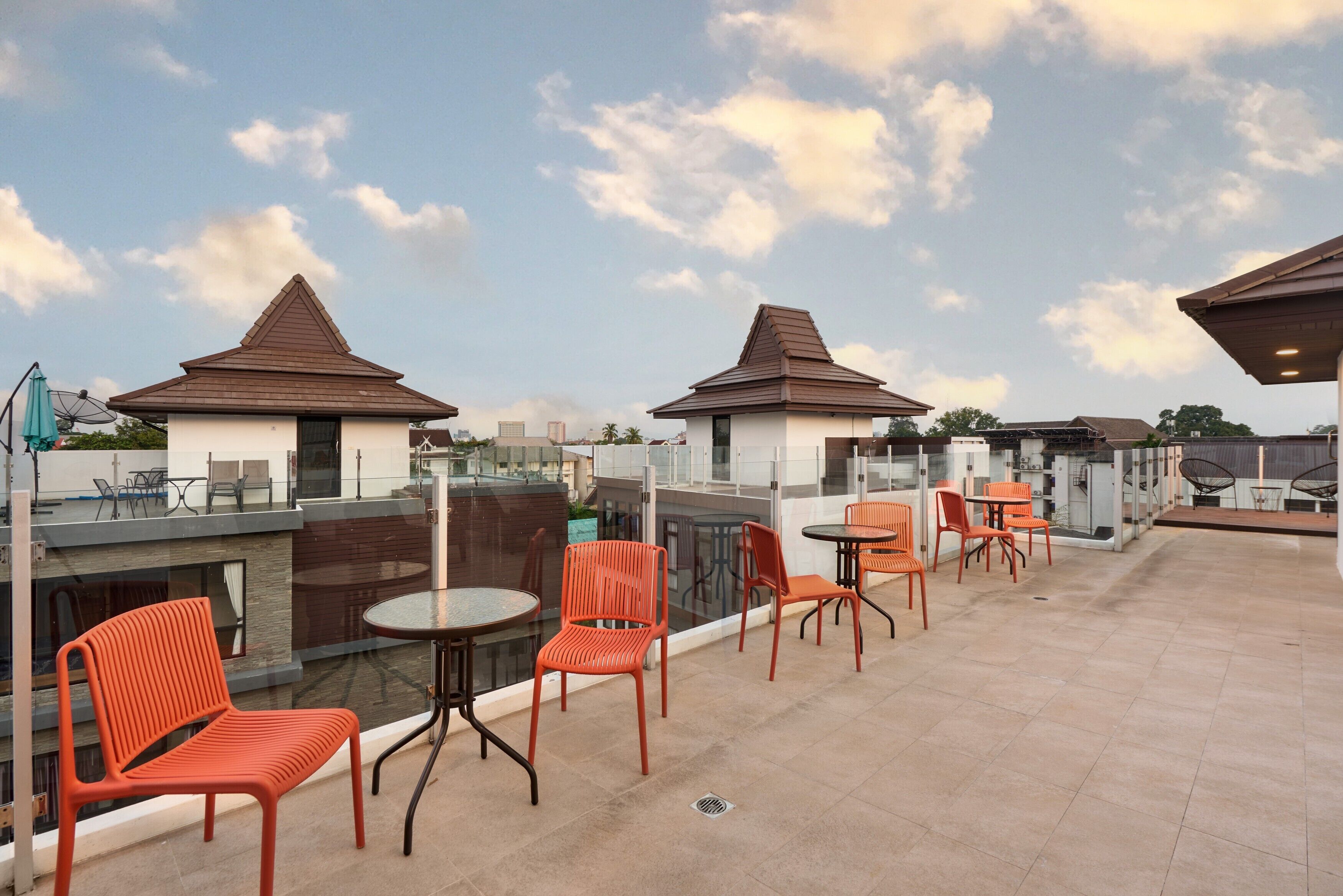 A rooftop terrace with outdoor seating, a pool, and a view of the city skyline.
