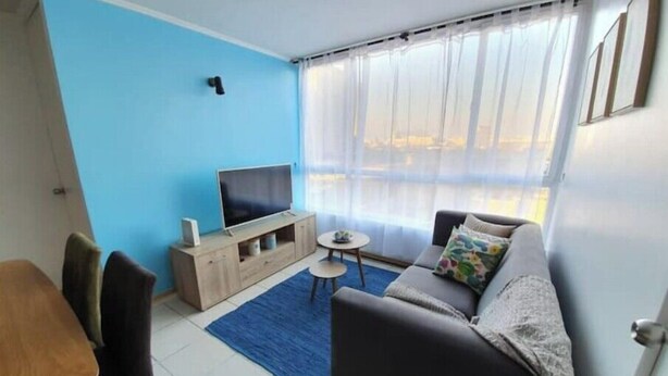 A living room with a TV, sofa, and chairs. - Beautiful apartment steps from the subway (Santiago)