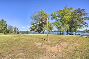 A volleyball net in a park with trees and a body of water in the background. - Lakefront Boating Getaway in Spring City! (Spring City)