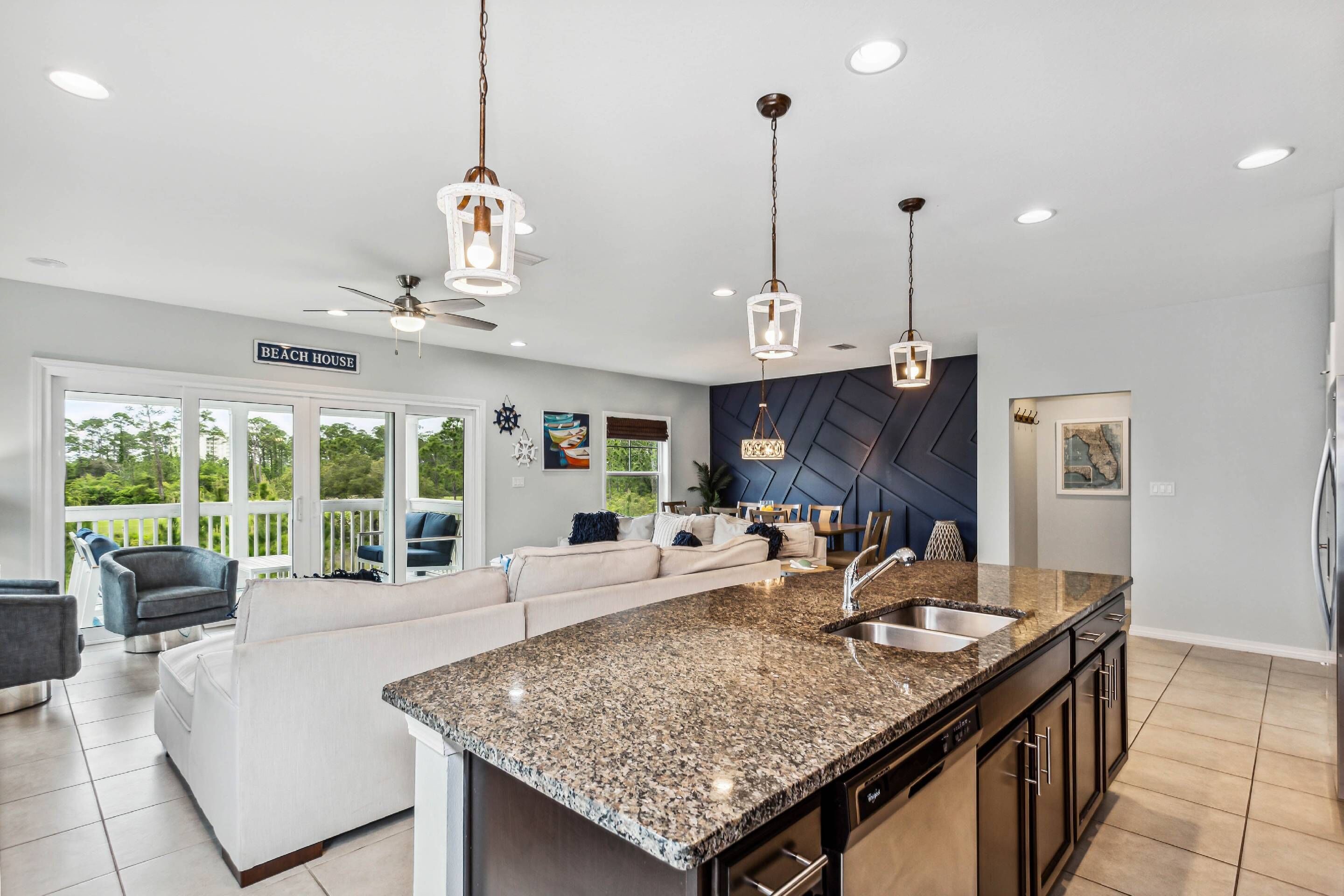 A modern kitchen with granite countertops, stainless steel appliances, and pendant lighting.