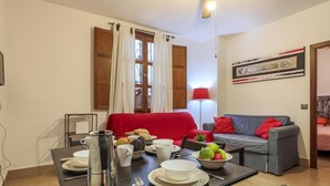 Un coin repas avec une table mise pour le petit-déjeuner, un canapé et une lampe.