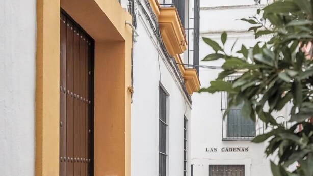 Un bâtiment à la façade blanche et à la partie jaune. On y voit une enseigne sur laquelle est écrit « LAS CADENAS ».