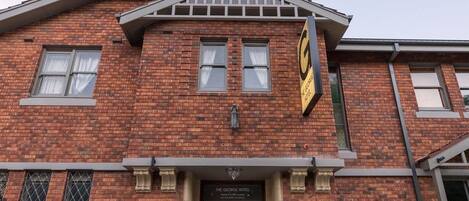 Un edificio de ladrillo con un cartel que dice "The George Hotel".