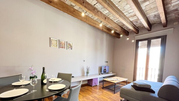 Ein modernes Wohnzimmer mit Essbereich, Holzboden und freiliegenden Backsteinwänden.