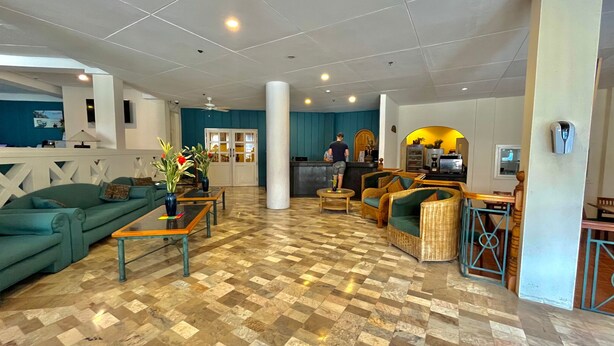 A spacious lobby with a checkered floor, a reception desk, and seating areas. - Coco Grande Hotel (Dumaguete)