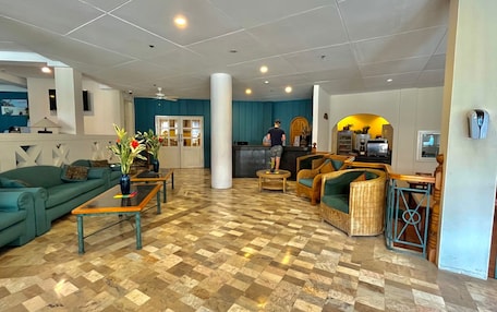 A spacious lobby with a checkered floor, a reception desk, and seating areas.