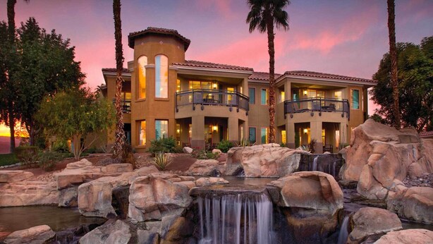 A multi-story hotel with a waterfall feature in the courtyard. - Marriott Resort Villas-Beautiful Palm Desert! Sleeps 8! (Palm Desert)