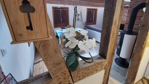 Estrutura de madeira rústica com um olho de chave, um arranjo de flores brancas e uma parede de tijolos ao fundo.
