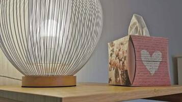 A table with a spherical lamp and a tissue box with a heart design.