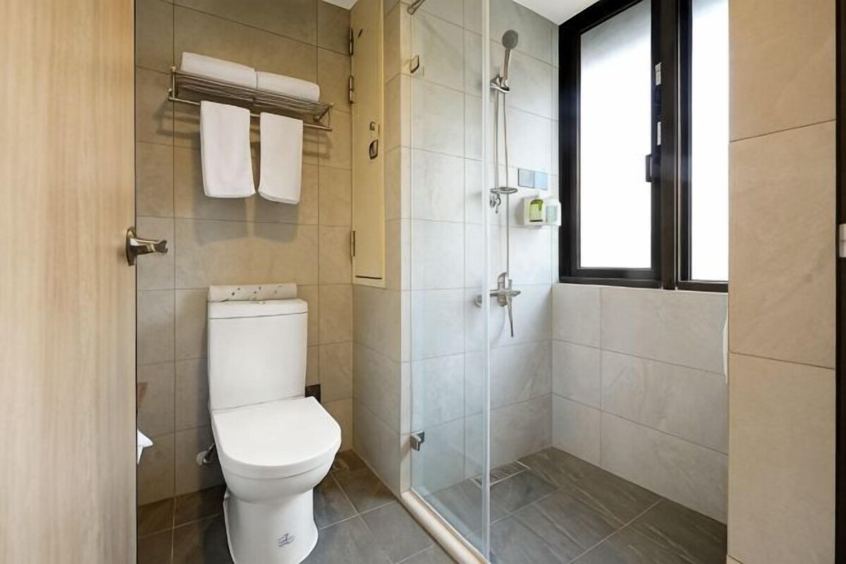 Une salle de bain moderne équipée de toilettes, d’une douche et d’une porte en verre.