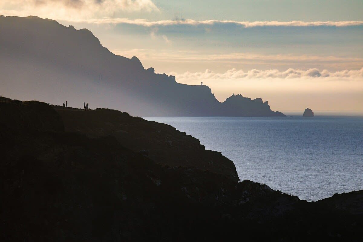 A coastal landscape with rocky cliffs and a calm sea.