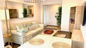 A modern living room with a sofa, coffee table, and a dining area with a table and chairs. - The Cliffs - Ria do Vicedo (O Vicedo)